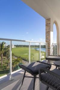 a balcony with chairs and a view of a golf course at Modern & relaxing penthouse Lake and Golf View in Punta Cana