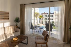 a living room with a couch and a large sliding glass door at Modern & relaxing penthouse Lake and Golf View in Punta Cana