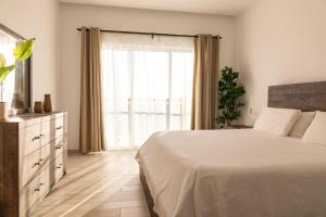a bedroom with a bed and a large window at Modern & relaxing penthouse Lake and Golf View in Punta Cana