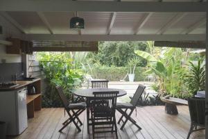 a patio with a table and chairs in a kitchen at LE SUNSET gîte côté canne in Grand-Bourg