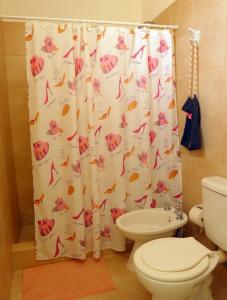 a bathroom with a toilet and a shower curtain at CASA FRANCA in Puerto Madryn