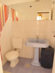 a bathroom with a white toilet and a sink at CASA FRANCA in Puerto Madryn
