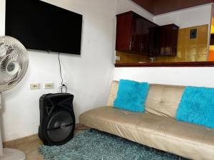a living room with a couch and a fan at Golden House II in Valledupar