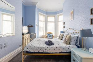 een blauwe slaapkamer met een bed en een raam bij Beach Shore - SEA VIEWS in Lytham St Annes