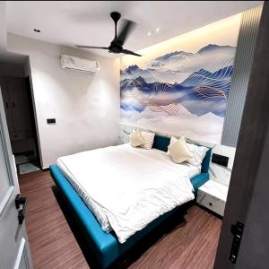 Schlafzimmer mit einem Bett mit Wandgemälde in der Unterkunft V Love Hotel in Surat
