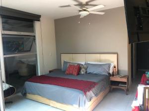 a bedroom with a bed with a ceiling fan at Departamento de lujo, exclusivo Terraza y jardín gh02 in Guadalajara