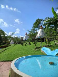 uma piscina de água com tendas ao fundo em Tipis Cuetzalan em Cuetzalan