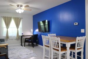 una sala da pranzo con parete blu e tavolo e sedie di Hidden Sapphire-Apartment with Kitchen and Laundry a Lakeland