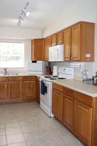 cocina con armarios de madera y horno de fogón blanco en Hidden Sapphire-Apartment with Kitchen and Laundry en Lakeland