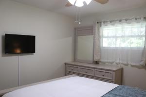 um quarto com uma cama, uma televisão e uma janela em Hidden Sapphire-Apartment with Kitchen and Laundry em Lakeland