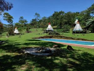 a resort with a swimming pool and some tents at Tipis Cuetzalan in Cuetzalán del Progreso
