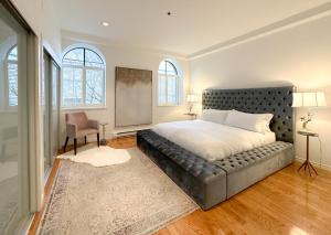 a bedroom with a bed and a couch and windows at Historic Townhouse in Kitsilano in Vancouver