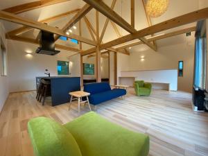una sala de estar con techos de madera y un sofá verde. en Gassan Pole Pole Farm, en Nishikawa