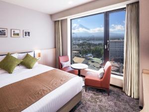 ein Hotelzimmer mit einem Bett und einem großen Fenster in der Unterkunft HOTEL MYSTAYS Fuji Onsen Resort in Fujiyoshida