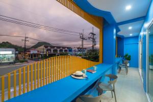 a blue balcony with a table with a hat on it at Otter House Aonang Intersection in Krabi town