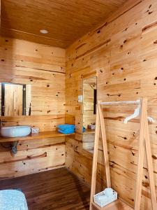 a log cabin with a bathroom with a sink at Lâm Bích Homestay & Coffee in Ấp Phước Thánh