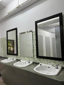 due lavandini in un bagno pubblico con due specchi di Happiness Hostel a Phra Ae beach