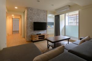 a living room with a couch and a tv at Three Master Bedrooms 4B4b Home 1min to SYS MRT 三主臥4房4衛 1分到國父紀念館站 in Taipei
