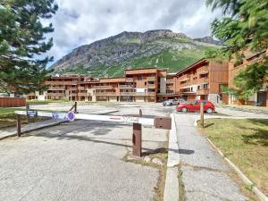 a parking lot in front of a building with a mountain at Appartement Val-d'Isère, 3 pièces, 6 personnes - FR-1-518-147 in Val-d'Isère