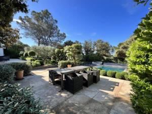 une terrasse avec une table, des chaises et une piscine dans l'établissement Villa Saumane-de-Vaucluse, 7 pièces, 10 personnes - FR-1-767-9, à Saumane-de-Vaucluse