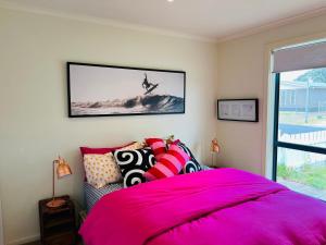 a bedroom with a pink bed with pillows on it at Lo Quay - Pet Friendly (small pets approved inside in Robe