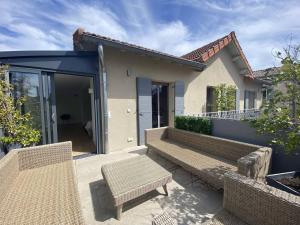 un patio con 2 bancos y una casa en Maison L'Isle-sur-la-Sorgue, 4 pièces, 6 personnes - FR-1-767-6, en LʼIsle-sur-la-Sorgue