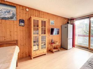 uma cozinha com paredes de madeira e um frigorífico num quarto em Studio Le Corbier, 1 pièce, 5 personnes - FR-1-267-279 em Villarembert