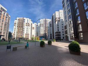 a person walking in a city with tall buildings at Аэропорт Кишинев 24&24 in Chişinău