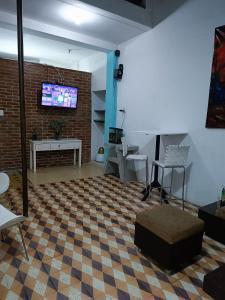 a living room with a tv on a brick wall at Quédate con Keny & Vivi in Ibagué