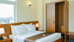 Postel nebo postele na pokoji v ubytování Bombo DaLat Hotel