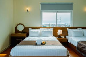 Postel nebo postele na pokoji v ubytování Bombo DaLat Hotel