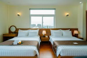 Postel nebo postele na pokoji v ubytování Bombo DaLat Hotel