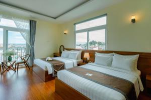 Postel nebo postele na pokoji v ubytování Bombo DaLat Hotel