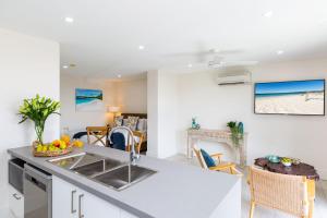 a kitchen and living room with a sink and a table at Ishtar Apartment 8- Luxury Studio in Huskisson