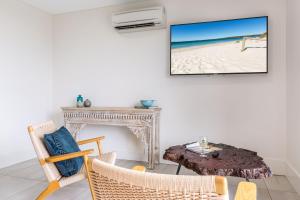 a living room with a fireplace and a tv on the wall at Ishtar Apartment 8- Luxury Studio in Huskisson