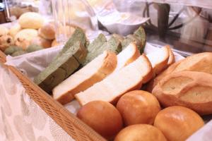 a basket filled with bread and some bread rolls and breadsticks at KOKO HOTEL Sendai Station West in Sendai