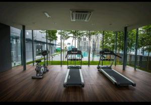 a gym with three treadmills in a room with windows at Dorsett Bukit Bintang Pavilion in Kuala Lumpur