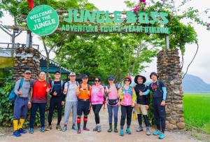 een groep mensen die onder een bord staan bij Jungle Boss Travel Lodge in Phong Nha