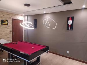 a billiard room with a red pool table at Apartamento com vista para piscina in Cataguases