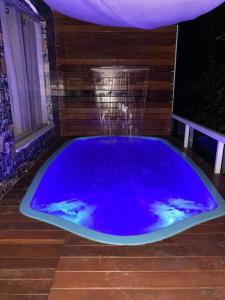 een grote blauwe badkuip met een fontein in een kamer bij Apartamento com vista para piscina in Cataguases