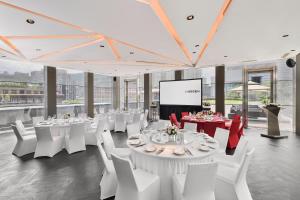 a conference room with white tables and chairs and a screen at Le Meridien Taipei in Taipei