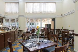 a dining room with tables and chairs and windows at Intercity Interative São Paulo Jardins in São Paulo