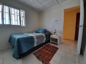 1 dormitorio con cama, ventana y alfombra en Bahía Inglesa arenas blancas y aguas turquesa, en Caldera
