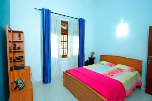 a bedroom with a bed and a blue wall at Estate Bungalow in Ratnapura