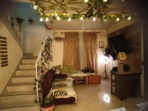 Pa Pasiar Hostal في ميديلين: غرفة معيشة بها درج وغرفة بها أريكة