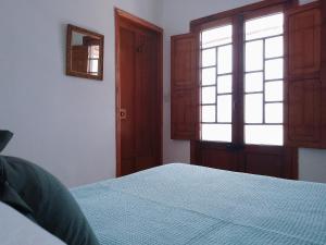 a bedroom with a bed and a window and a mirror at Casita de Piedra in Bogotá
