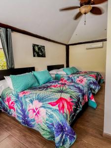 1 dormitorio con 1 cama con un edredón colorido en Casa Los Ninos en Sámara