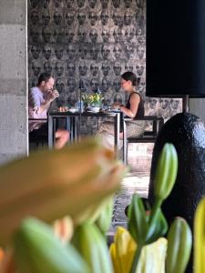 a man and woman sitting at a table in a restaurant at Saffron Robes Living in Hikkaduwa