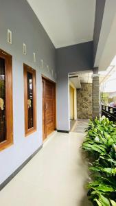 un couloir vide avec une porte en bois et des plantes dans l'établissement Homestay Jogja Omah Palagan, à Kejayan