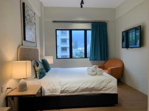 Urban Living Residence في كوالالمبور: غرفة نوم بسرير وكرسي ونافذة